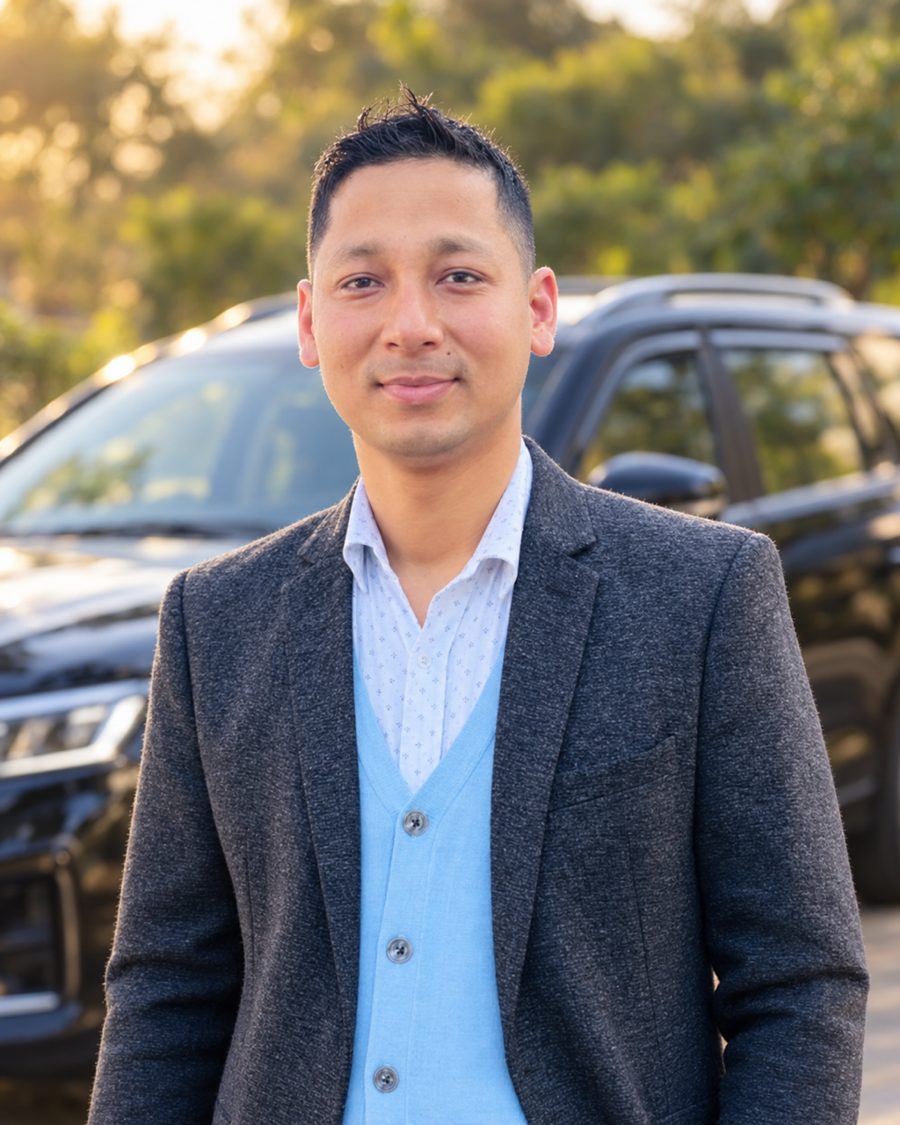 Bishal Joshi, owner of Joshi Car Rental, standing in front of a black SUV